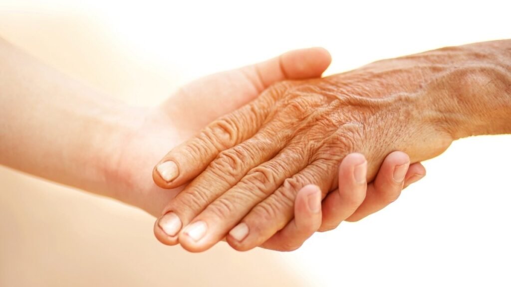 Young-hand-holding-older-wrinkled-hand-